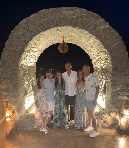 Dr. Sarah Eley poses with her family beneath an archway in Greece.